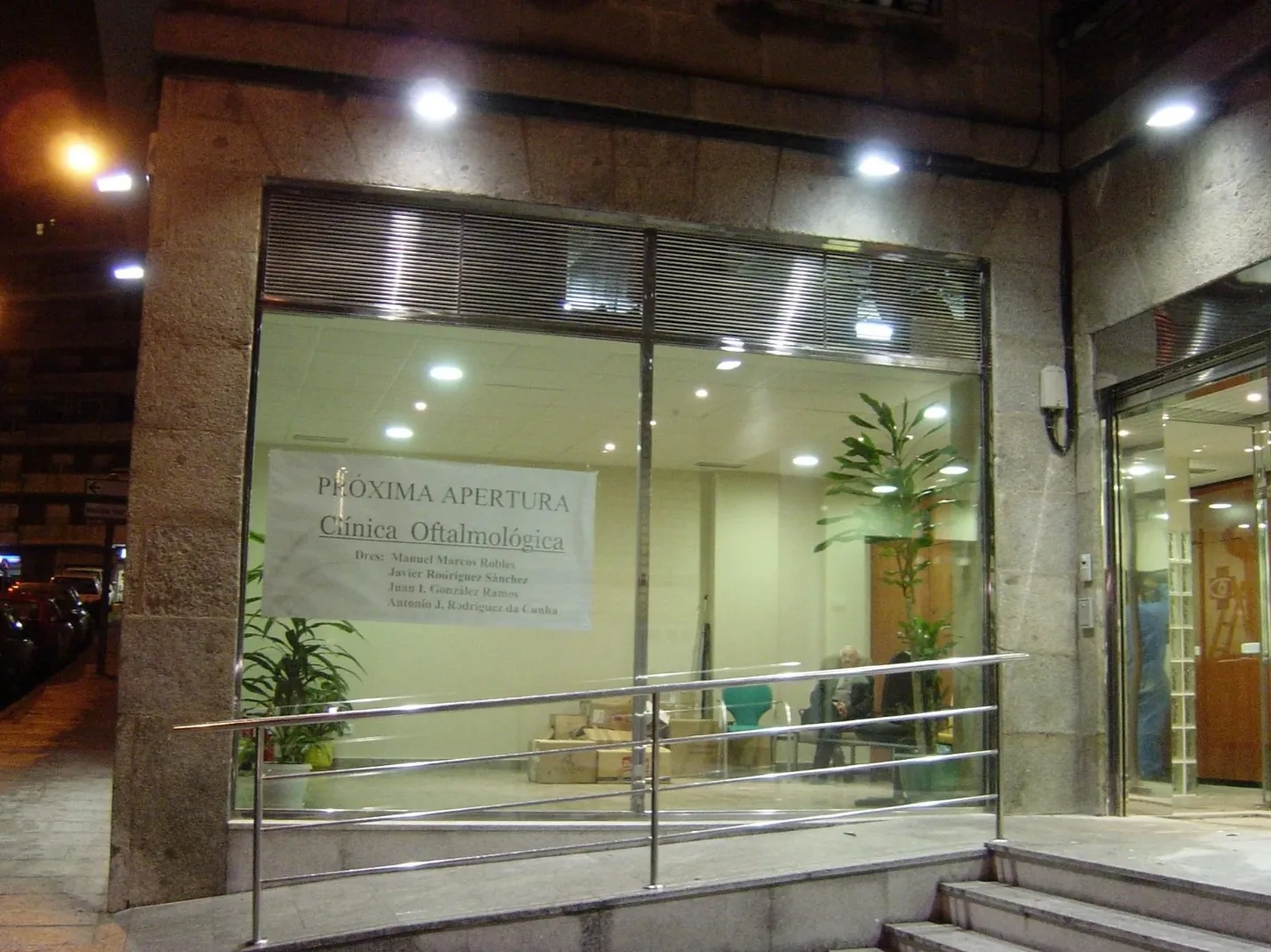 Fachada comercial, carpintería acristalada y barandilla de rampa accesible