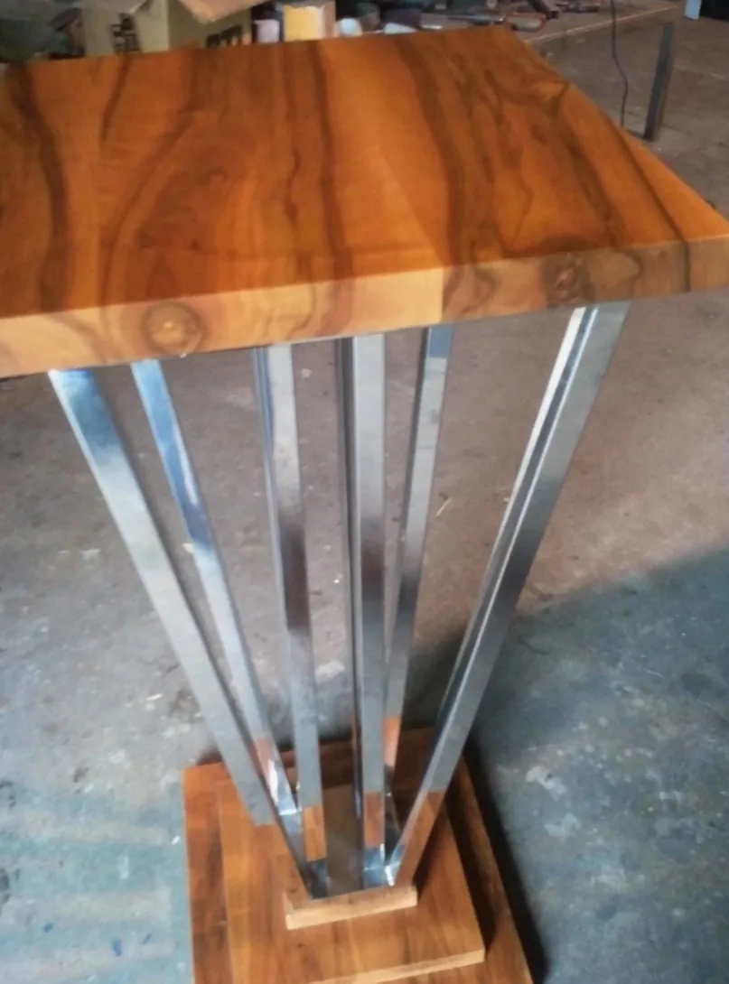 Mesa de diseño combinando madera maciza y estructura geométrica inox